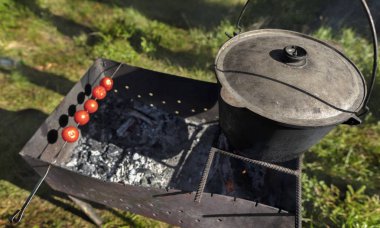 Eski kazanda püresi öğlen temizleyerek bir orman karşı pişirme Barbekü üzerinde