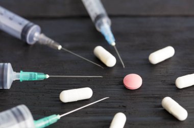 Eski bir siyah ahşap kurulu çeşitli kapasitelerde, kapsül, Tablet tıbbi şırınga yalan.