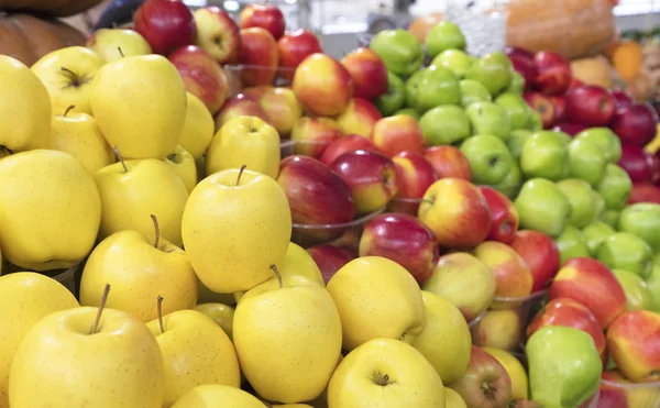 Сочный яблочный фон из желтого, красного, зеленого фрукта для продажи на рынке — стоковое фото