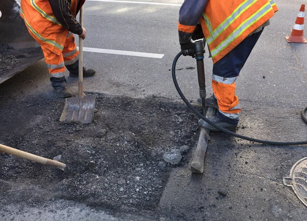 La brigada de trabajadores despeja una parte del asfalto con palas en la construcción de carreteras — Foto de Stock