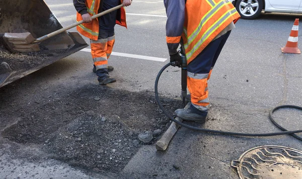 La brigada de trabajadores despeja una parte del asfalto con palas en la construcción de carreteras — Foto de Stock