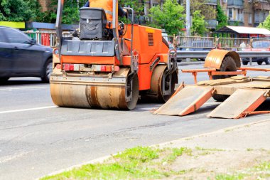 Ağır titreşimli yol silindiri, alçak platformlu bir karavandan indirilir ve yolda durur..