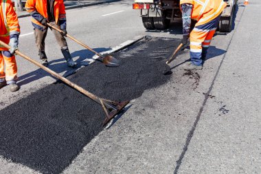Yol inşaat kürek ile asfalt bir parçası işçi Tugay temizler