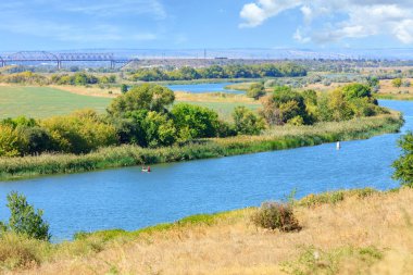Güney Bug Nehri manzarası ve ufuktaki demiryolu köprüsü.
