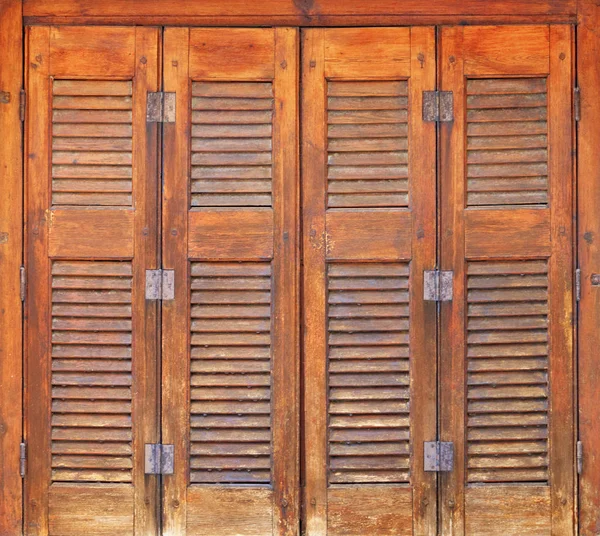 Old orange wooden windows with wooden shutters and metal hinges in the Greek style. — 스톡 사진