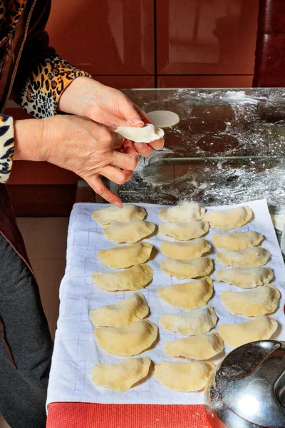 Женщина разбрасывает готовые сырые пельмени на салфетке . — стоковое фото