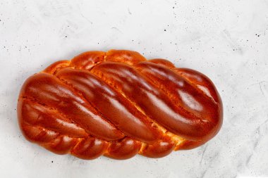 Taze hasır tatlı rulo, gri betondan bir arka planda kalach. Üst görünüm.