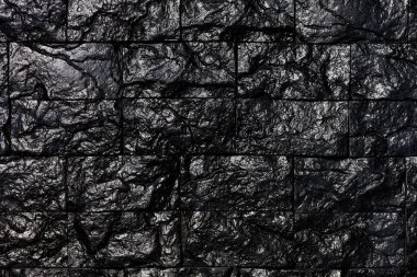 Siyah kömürün dokusu ve arkaplanı için desenli dikdörtgenlerle kaplı alışılmadık dekoratif fayanslar..