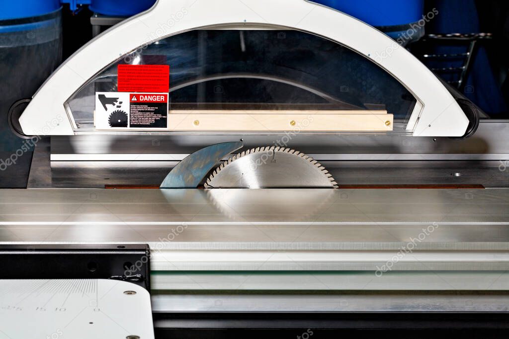 A modern woodworking machine with an aluminum profile, a protractor and protection for the precise sawing of wooden materials, close-up.