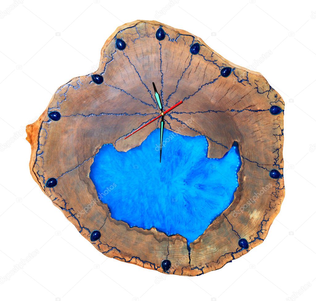 Beautiful wooden wall clock made of cut tree roots and translucent blue epoxy on the dial in the form of a clean lake, isolated on white background.