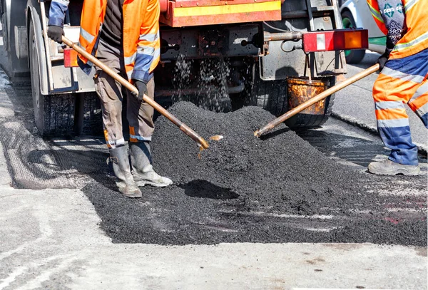 道路工人工作组用铲子用新鲜沥青更新了部分道路 以便在道路建设中加以更新 并逐字逐句 复制空间 — 图库照片