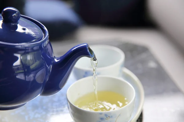 Verser le thé dans une tasse de thé en gros plan chinois et japonais boisson — Photo