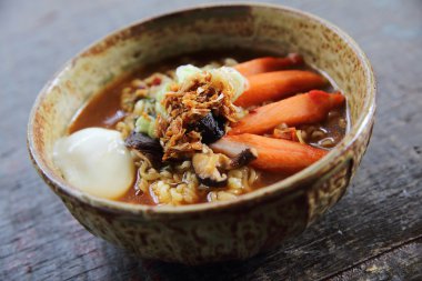 Ahşap arka plan üzerinde yumurta baharatlı çorba ile erişte 