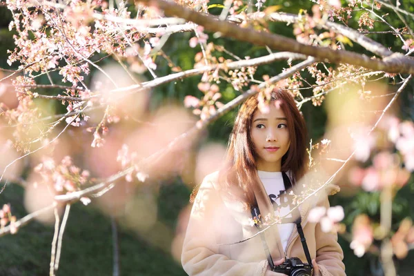 Hermosa mujer joven tomar una foto con flores de cerezo en flor —  Fotos de Stock