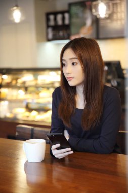 bir Asyalı kadın ile akıllı telefon düşünme