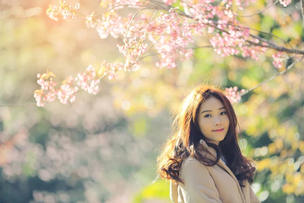 Mulher asiática com flor de cereja natureza fundo — Fotografia de Stock