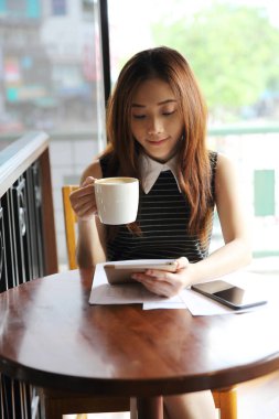 Asyalı kadın tablet ile kahve içme