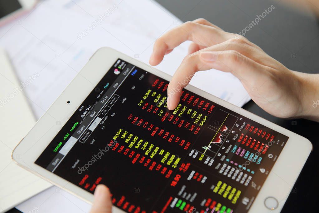 Woman hand Trading online on tablet with business paper and coff