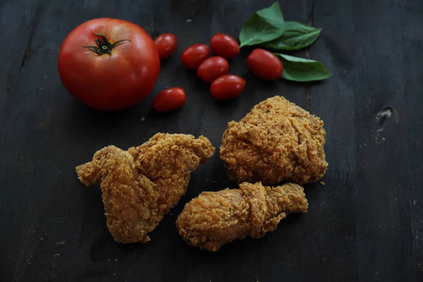 Fried Chicken domates ile darken ahşap arka plan — Stok fotoğraf