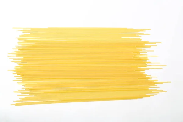 Сырая лапша-спагетти на белом фоне — стоковое фото