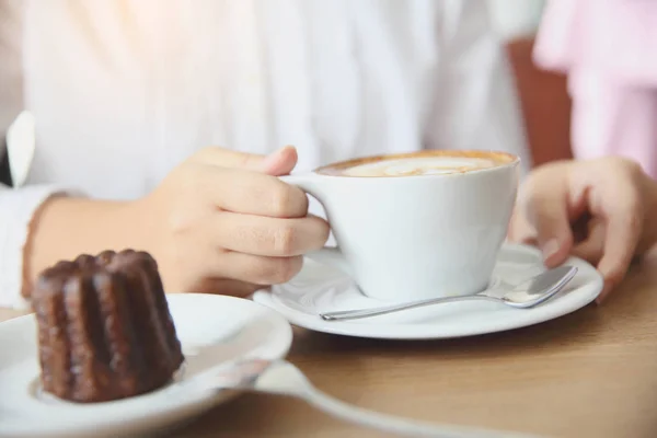 Frau reicht Cappuccino-Kaffee auf Holztisch — Stockfoto