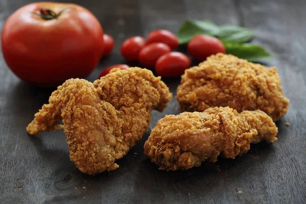 Fried Chicken with tomato in darken wood background — Stock Photo, Image