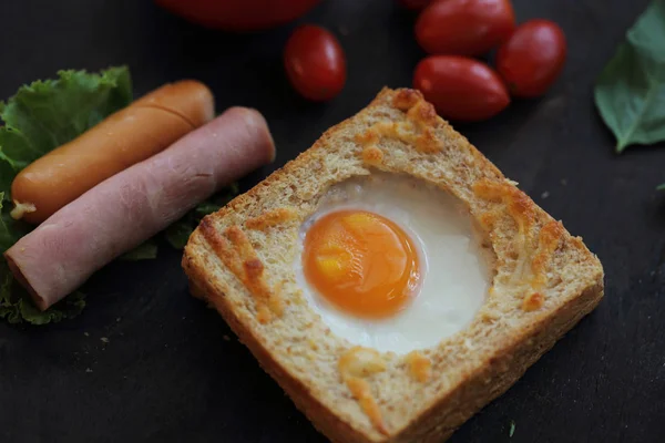 Egg in bread on wooden background — Stock Photo, Image