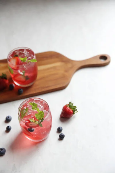 Cocktail di succo di fragola con ghiaccio e menta su tono bianco amd wo — Foto Stock