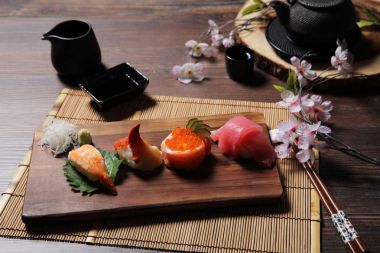 Suşi Set sashimi ve suşi rulo çay ile ahşap arka plan üzerinde