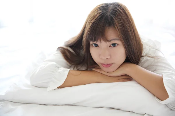 Азіатських молода жінка прокинетеся з подушкою у білій кімнаті — стокове фото