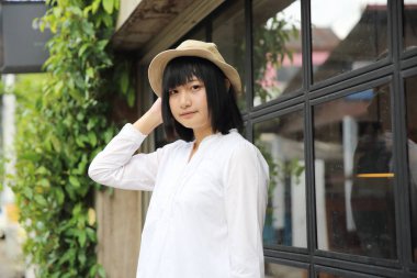 Asyalı genç kadın düşünme ve portre ile kahve s arıyor