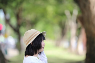 Düşünme ve yeşil ağaç ile portre seyir Asyalı genç kadın 