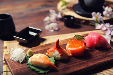 Suşi Set sashimi ve suşi rulo çay ile ahşap arka plan üzerinde