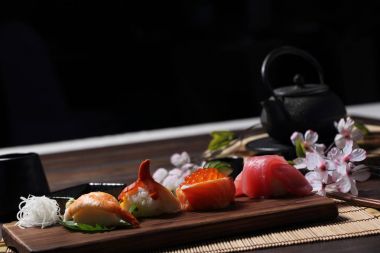 Suşi Set sashimi ve suşi rulo çay ile ahşap arka plan üzerinde