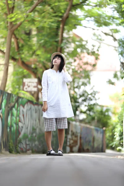 Aziatische jonge vrouw denken en op zoek portret met groene boom — Stockfoto