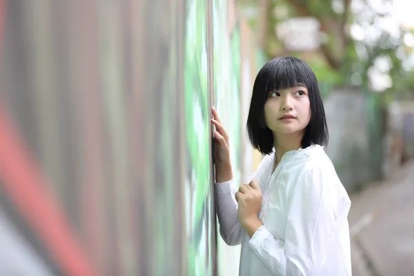 Aziatische jonge vrouw denken en op zoek portret met groene boom — Stockfoto