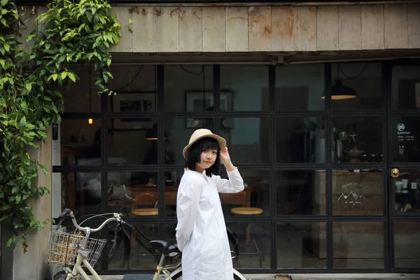 Aziatische jonge vrouw denken en op zoek portret met in koffie s — Stockfoto