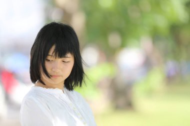 Düşünme ve yeşil ağaç ile portre seyir Asyalı genç kadın 