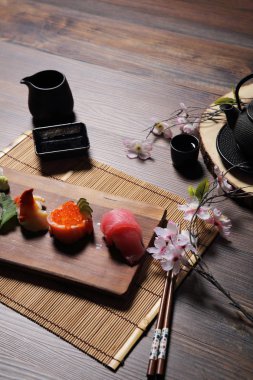 Suşi Set sashimi ve suşi rulo çay ile ahşap arka plan üzerinde