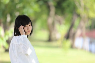 Düşünme ve yeşil ağaç ile portre seyir Asyalı genç kadın 