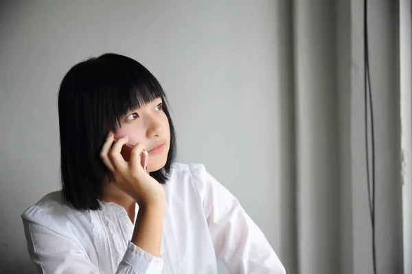 Aziatische jonge vrouw praten met smartphone portret in koffie sho — Stockfoto