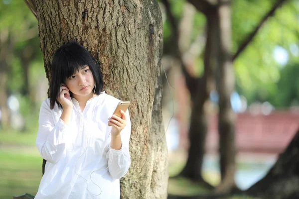 关于智能手机肖像与 g 亚洲年轻女人听音乐 — 图库照片