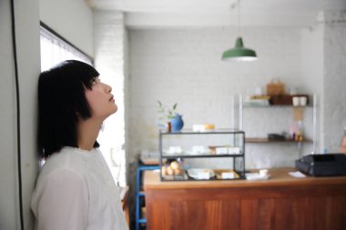 Düşünme ve kahve dükkanı C'de portre seyir Asyalı genç kadın