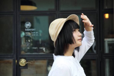 Asyalı genç kadın düşünme ve portre ile kahve s arıyor