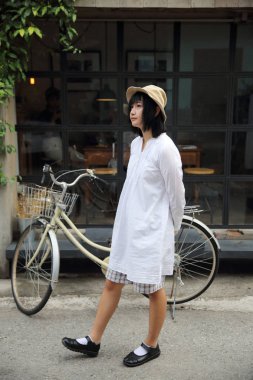 Asyalı genç kadın düşünme ve portre ile kahve s arıyor