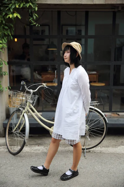 Asyalı genç kadın düşünme ve portre ile kahve s arıyor