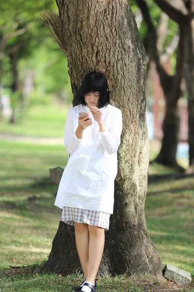 Asiatka mladá žena poslech hudby na chytrý telefon portrét s g — Stock fotografie