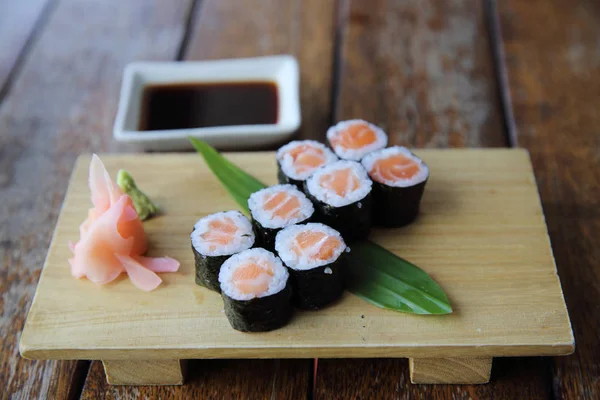 Salmón maki sushi sobre fondo de madera, comida japonesa —  Fotos de Stock