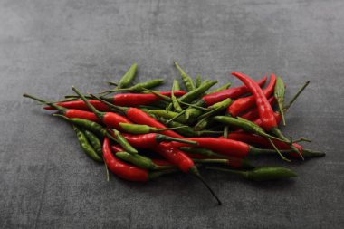 Koyu kaya arka plan üzerinde kırmızı ve yeşil biber