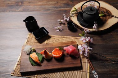 Suşi Set sashimi ve suşi rulo çay ile ahşap arka plan üzerinde